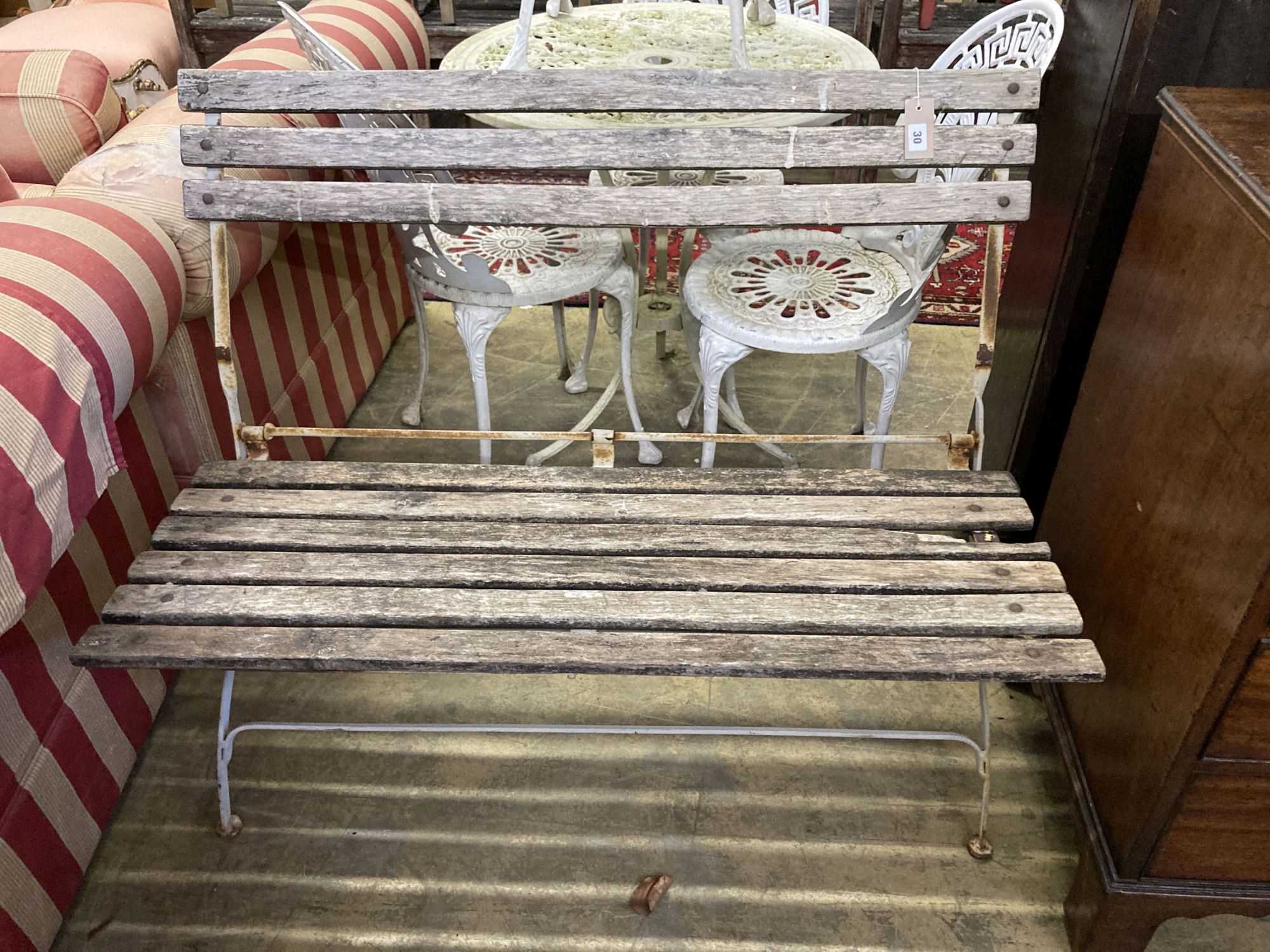 A wrought iron slatted folding garden bench, length 105cm, depth 52cm, height 86cm together with a rectangular garden table, length 122